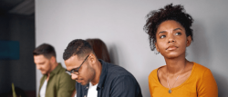 a row of three people sitting down